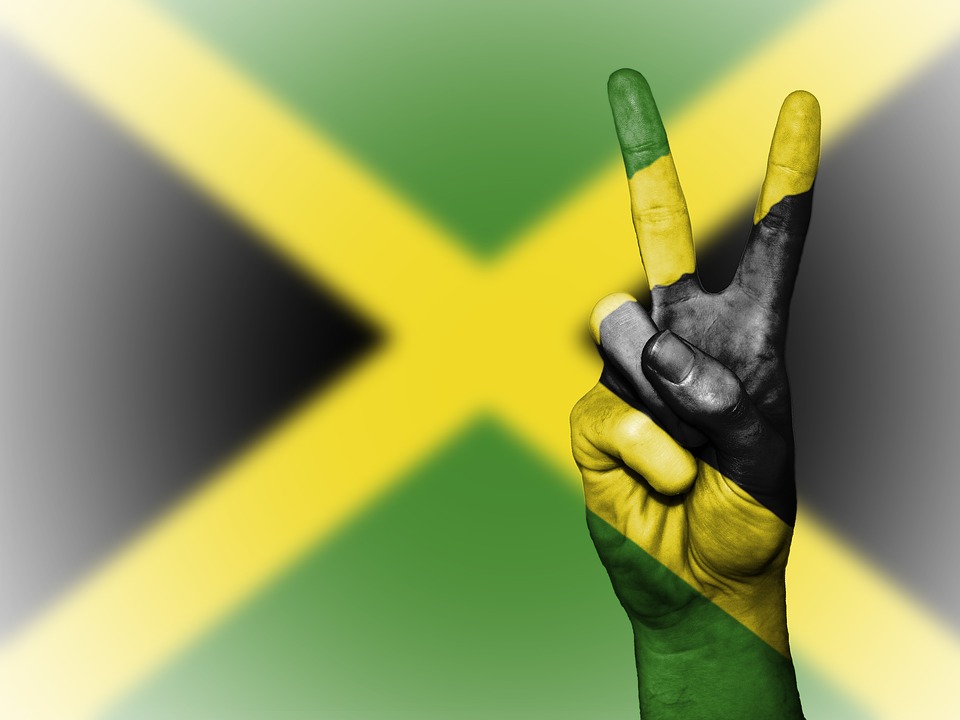 Flag of Jamaica with a hand making the sign of peace.