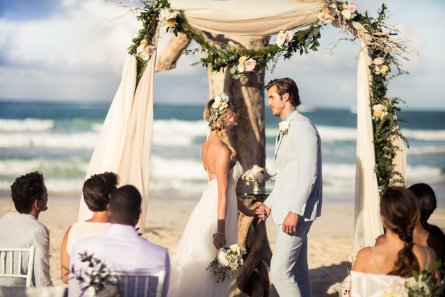 Couple on the beach having a Driftwood Romance Wedding Ceremony.