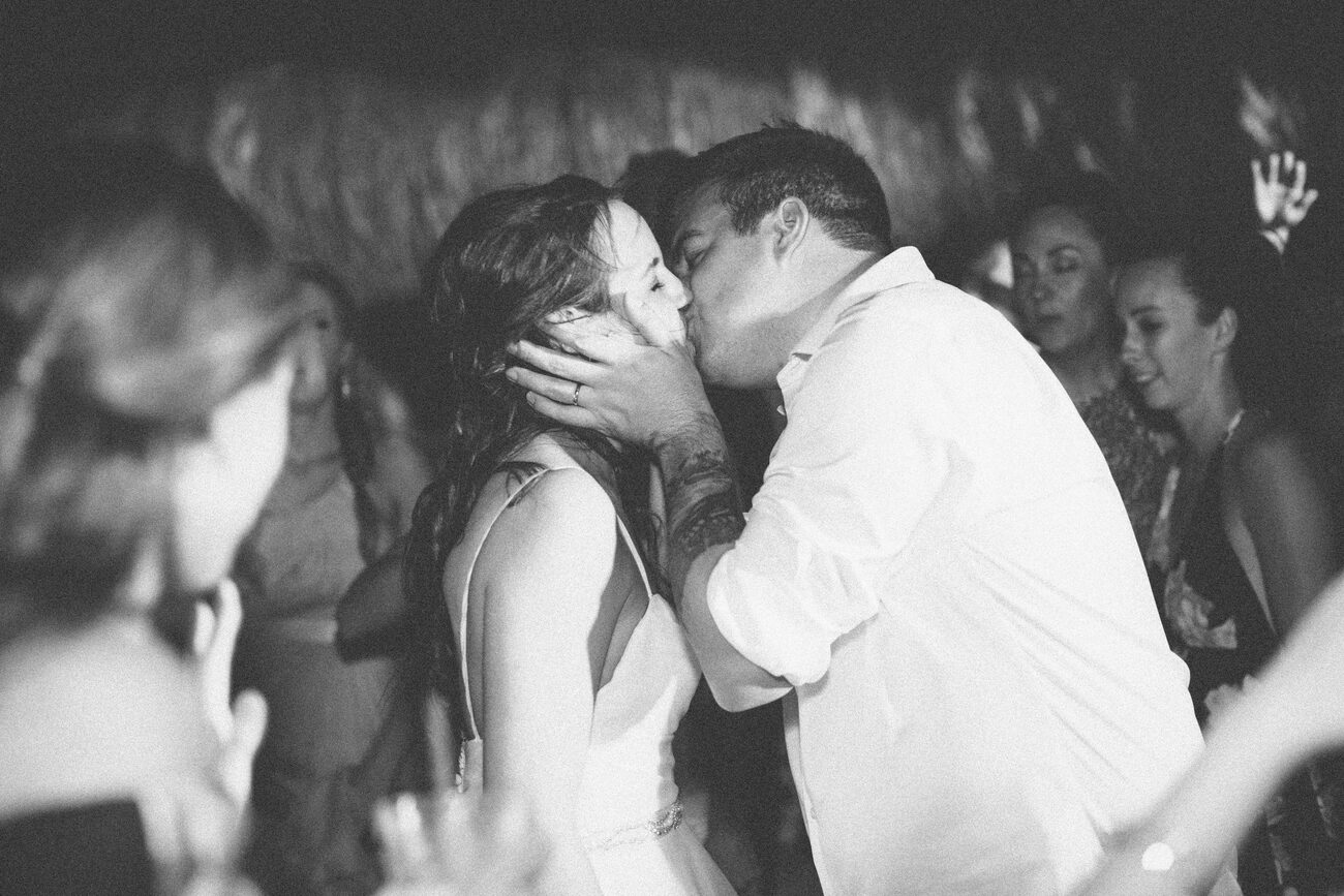 Couples share a wedding reception kiss.