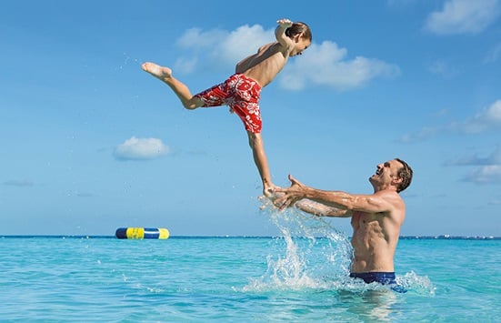 Father playing with son at the beach