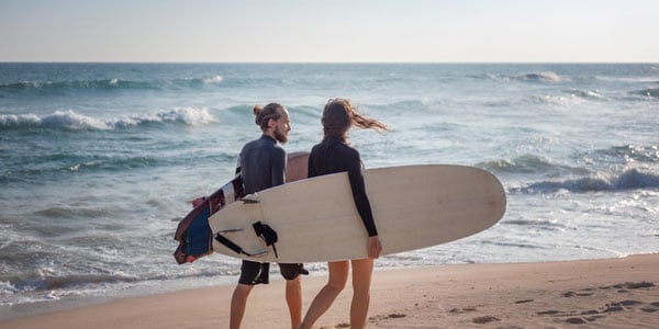 Couple walking with surfboards